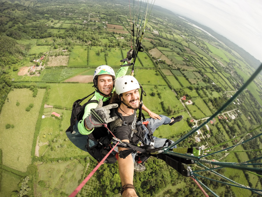 smiling, paragliding, in the air, gopro, fields, landscape, https://wetravelandblog.com
